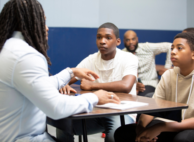 Two Young adults talking to a professional