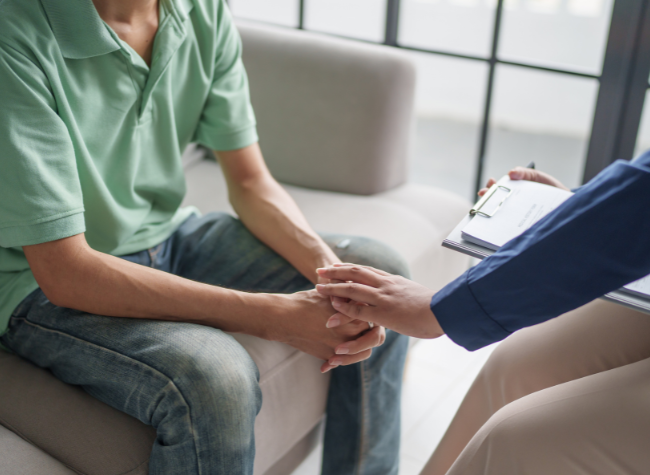 two people talking one holding the others hand