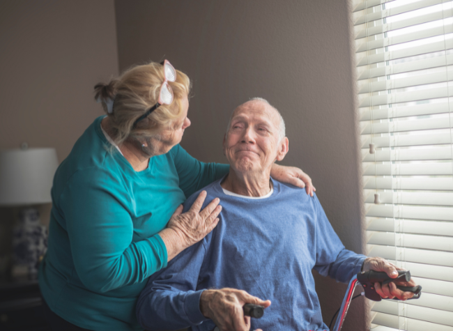Image of man with crutches and his wife with her arm around him